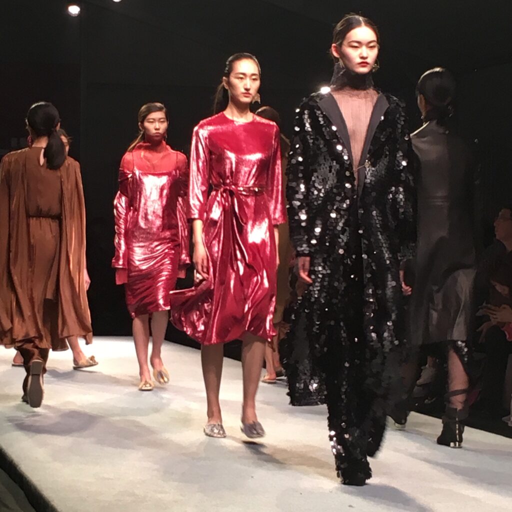 Models walking the runway in red and burgundy patterned knitwear